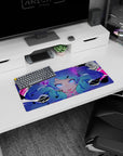 Blue twin-tail anime girl staring forward on a 28x12 inches mouse pad, violet eyes with splatter effects.