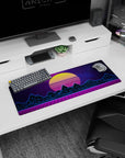 Artistic 32x12 inches mouse pad featuring synthwave design, with a glowing yellow sunset, neon blue mountains, and purple grid landscape.