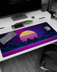 Large 40x20 inches desk pad featuring synthwave design, blending a yellow sunset, neon blue mountains, and a purple grid for futuristic 80s nostalgia.