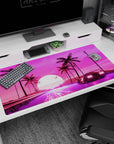 Large 40x20 inches desk pad featuring synthwave design, with a neon-lit road, retro car, palm trees, and glowing retrowave sun for nostalgic energy.