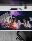 40x20 inches anime desk pad in warm firelight and deep violet starry sky, calm magical camping mood.