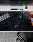 Midnight navy and inky black desk pad 40x20 inches with starry specks and a warm orange nebula.