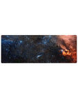 Midnight galaxy desk mouse pad 32x12 inches with star-speckled swirl design and orange nebula edge.