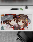 Megumin and Yunyun from Konosuba on a 32x16 inch anime mouse pad, featuring chibi Chomusuke and vibrant school day chaos.