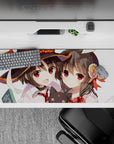 Megumin and Yunyun from Konosuba on a 36x16 inch anime desk pad, featuring chibi Chomusuke and playful magic chaos.