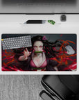 Nezuko anime mouse pad 32x16 inches with fierce design, pink eyes, and dynamic hair against a blazing red background.