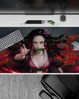 Nezuko anime desk pad 40x20 inches with fierce design, pink eyes, and dynamic hair in a burning red haze.
