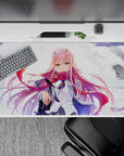 Dynamic 40x20 desk pad capturing Zero Two’s fierce emerald eyes, flowing pink hair, and windswept background for powerful vibe