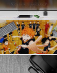 Vibrant 40x20 inches anime desk pad, warm wood tones, black uniforms, orange hair, loud team-spirit energy.