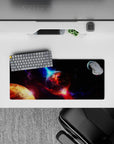 Cinematic galaxy mouse pad 28x12 inches in inky black, violet dust glow, and electric blue highlights.