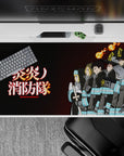 Dark charcoal Fire Force desk pad 40x20 inches with turquoise bands, warm orange flames, calm blaze mood.