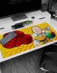 Saitama in yellow suit and white cape throwing a red glove on anime desk pad 40x20 inches.
