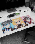 KonoSuba desk pad 36x16 inches featuring Aqua, Darkness, and Megumin in maid outfits with pastel colors and fun expressions.