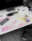Sailor Moon anime desk pad 40x20 inches, arm raised in victory amid drifting petals and pastel skies.