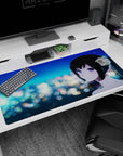Anime girl with violet eyes and black ponytail against dreamy night city lights desk pad 40x20 inches.