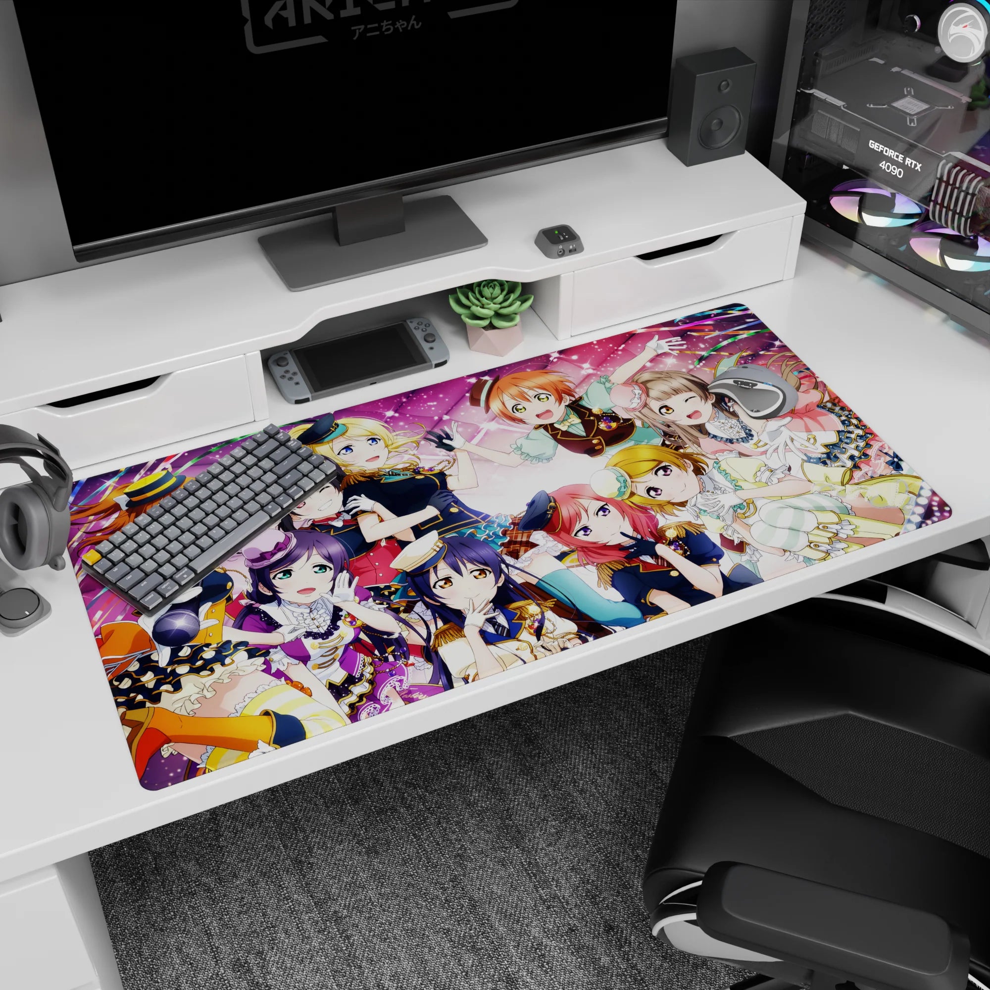 Honoka and friends in sparkly group hug with tiny hats and frills on desk pad, 40x20 inches.