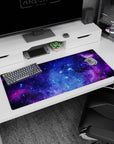 Swirling nebula clouds and inky deep-space pockets desk pad, 36x16 inches, star-dusted scene.