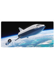 Space-vibes desk mouse pad 32x16 inches with silver spaceship over clouds and ocean horizon.