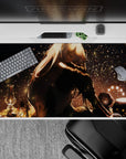 Moody warm-gold anime desk pad 40x20 inches with deep shadows, soft glow, and firefly-like sparkles.