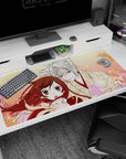 Anime desk pad 40x20 inches showing fox boy in paw-print kimono leaning close to scarfed girl under sakura.