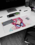 32x16 inches anime girl desk mat featuring flustered pink-haired girl pausing your music in chunky navy headphones.
