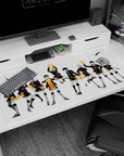 Hinata mid-jump beside cool Kageyama on anime desk pad 40x20 inches, team in black jackets, orange shorts.
