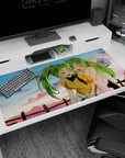 Anime desk pad 40x20 inches showing two green-haired besties with ponytails giggling by a fence at dusk.