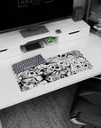 28x12 inches anime mouse pad showing a hypnotic swirl of skull-masked faces and hollow eyes in manga ink.