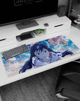 Cute braided anime girl leaning in to cheer you on, desk pad 36x16 inches with floating light runes.