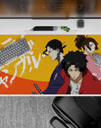 40x20 inches anime desk pad in bold orange heat with red, indigo, and pink characters, street-poster vibe.