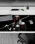 36x16 inches anime desk pad in dark cinematic tones, black backdrop with bone-white armor and red sparks.