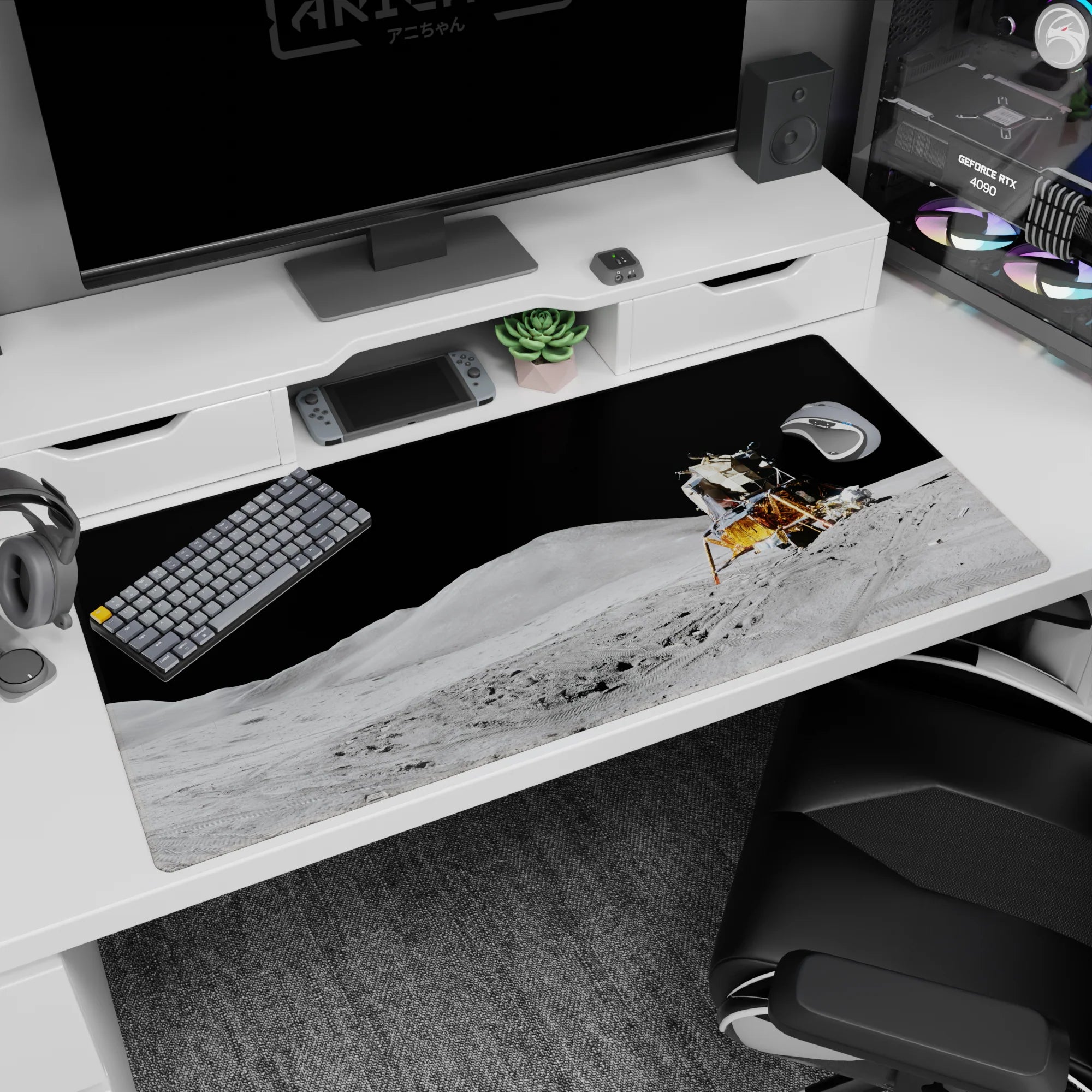 Tiny gold lunar lander on moon dust desk pad 40x20 inches, with gritty tracks and sharp shadows.