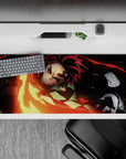 Anime mouse pad featuring Tanjiro from Demon Slayer, sword ablaze in reds and golds, 36x16 inches.