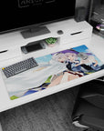 Two silver-haired anime girls cuddling, one in a violet witch hat, desk pad 36x16 inches.