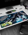 Gundam Wing Zero aiming twin blasters at the desk on an anime desk pad 40x20 inches, wings spread wide.