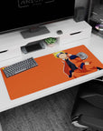 Naruto Uzumaki smiling in an orange jacket on a sunset backdrop desk pad, 36x16 inches.