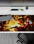 Anime girl desk pad 36x16 inches in fiery orange-gold glow with smoky shadows and bright red accents.