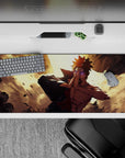 36x16 inches anime desk pad in warm gold light with bold contrast, flying debris, and chaotic energy.