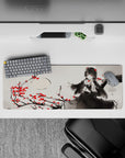 Moody ink-wash gray anime desk mat 32x12 inches with crimson blossoms and red-eyed gothic vibe.