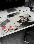 Raven-haired doll-like anime girl on branches with scattered red roses desk pad 40x20 inches.