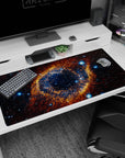 Large cosmic eye nebula with bright pinpoints on dark space desk pad, 40x20 inches.