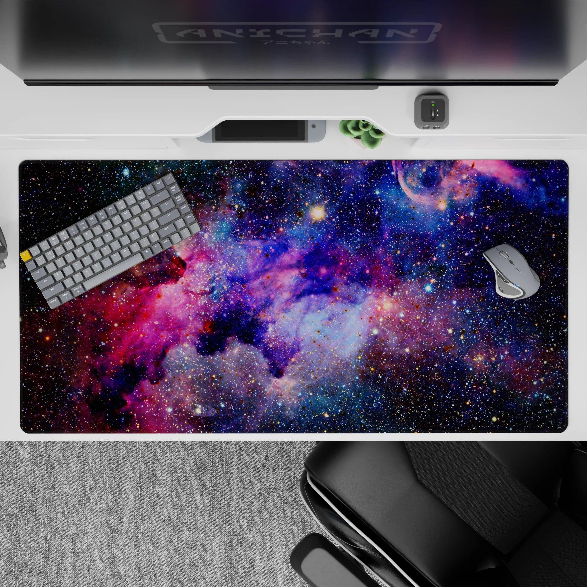 Moody space desk pad 40x20 inches in deep blues, inky purples, and punchy pinks with dreamy glow.