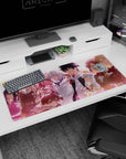 Playful grinning girl and cool silver-haired teammate on anime desk pad 36x16 inches, facing forward.