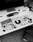 Blonde anime girl leaning in with sly grin in deep V black top on manga desk pad 36x16 inches.