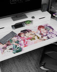 Glasses-wearing anime lead surrounded by sharp-eyed schoolgirls on a 40x20 inches desk pad, petals drifting.