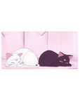 Anime mouse pad 32x16 inches with two moon-marked cats in a pink room with glowing curtains.