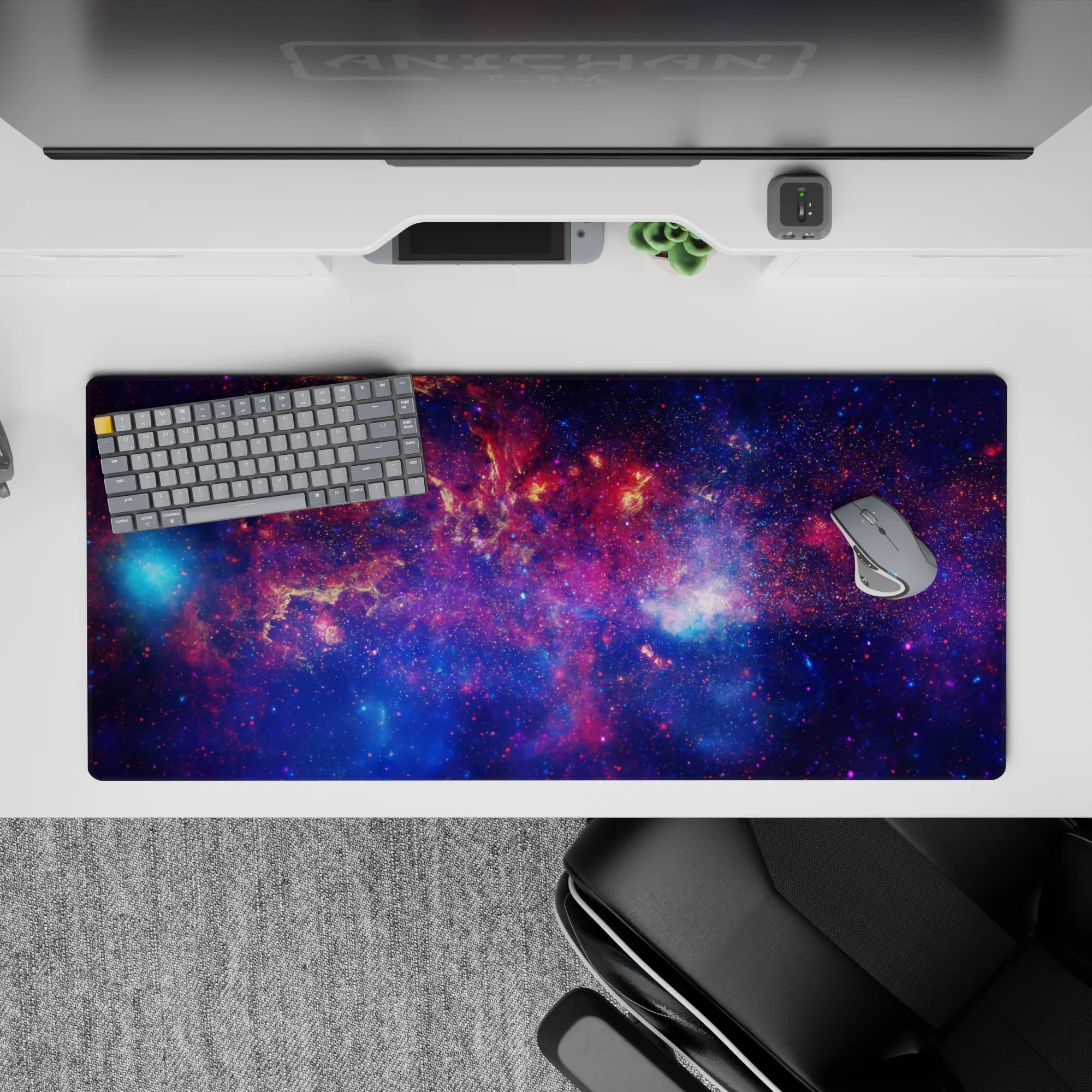 Cosmic desk pad 36x16 inches in deep violet and midnight blue with sparkly nebula pink glow.