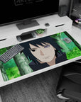40x20 inches desk pad showing Sasuke Uchiha staring ahead, dark hair framed by blurred green woods.