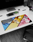 Close-up trio of anime girls with sharp eyes and smirks in comic panels on a 32x16 inches desk mat.