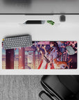 32x12 inches desk mat in pink, plum, and warm gold with soft lantern light and drifting sakura mood.